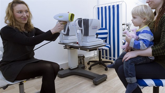 Optometristka s přístrojem Plusoptix měří zrak dítěte.