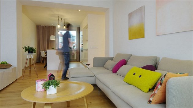 Dřevěnou podlahu a bílý nábytek pak podtrhují doplňky s výraznou veselou barevností. 
