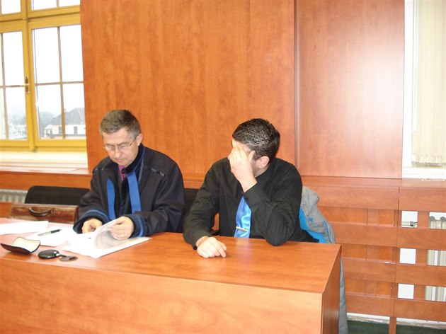 Obalovaný Nikola Raduljev si u soudu ped novinái zakrýval obliej. Vlevo na...