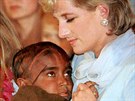 Diana Princess of Wales cradles a young child stricken with cancer during a...
