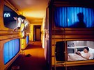 Kapslový hotel v Tokiu. V pokojíku je postel, osvtlení a televize. Koupelny...