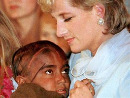 Diana Princess of Wales cradles a young child stricken with cancer during a...
