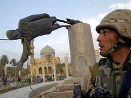 U.S. Marine Corp Assaultman Kirk Dalrymple watches as a statue of Iraq's...