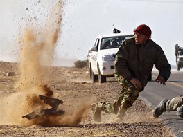 Rebel fighters jump away from shrapnel during heavy shelling by forces loyal...