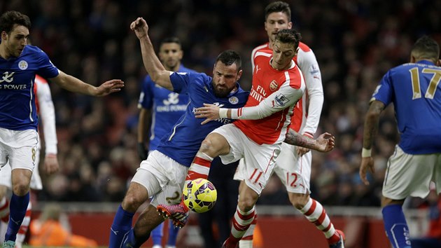 Mesut zil (vpravo) z Arsenalu v souboji s Marcinem Wasilewskim z Leicesteru.