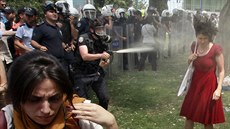 A Turkish riot policeman uses tear gas as people protest against...