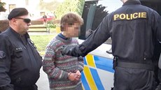 Policejní eskorta odvádí mladého mu�e, podez�elého z vra�dy man�elského páru z...