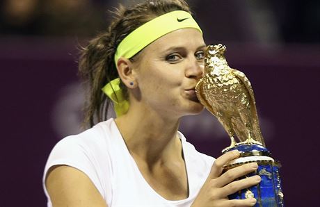 Lucie afáová líbá trofej pro vítzku turnaje v Dauhá.