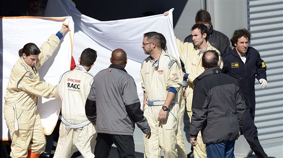 JAK JE NA TOM. Zdravotníci zakrývají Fernanda Alonsa z týmu McLaren, kterého po...