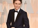 Eddie Redmayne v modrém obleku Alexander McQueen, erným motýlkem a platinovými...