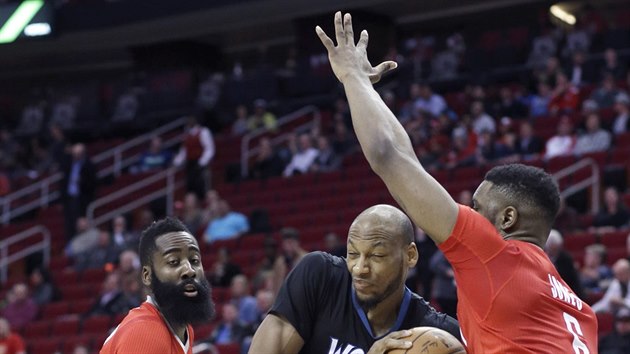 Adreian Payne (uprosted) z Minnesoty se cpe mezi dvojici James Harden (vlevo) a Terrence Jones z Houstonu.