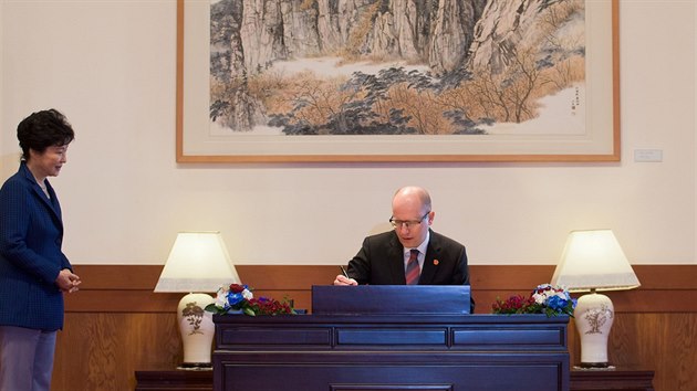Premir Sobotka se podepisuje do ntvn knihy v sdle prezidentky Jin Koreji (26. nora 2015).