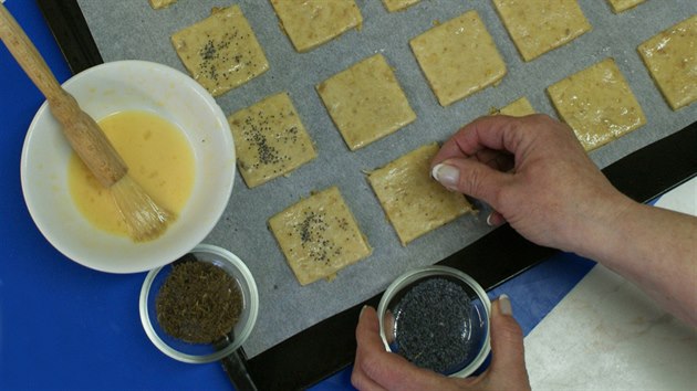 Kousky p�elo�te na plech vylo�en� pe�ic�m pap�rem. Ka�d� kousek pot�ete roz�lehan�m vejcem, posypte m�kem nebo km�nem a upe�te.