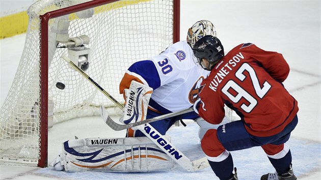 Jevgenij Kuzncov z Washingtonu pekonv branke Chada Johnsona z New York Islanders.