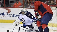 DO BEZPEÍ. Branká Winnipegu Ondej Pavelec zasahuje, dotírá na nj Alexandr...