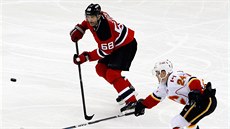 Jaromír Jágr (vlevo) jet v dresu New Jersey uniká Jiímu Hudlerovi z Calgary.