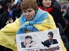 ena na smutením pochodu je v ukrajinské vlajce a plakátem zobrazující mimo...