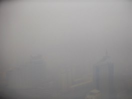 A combination picture shows buildings on a sunny day (L) and a polluted day in...