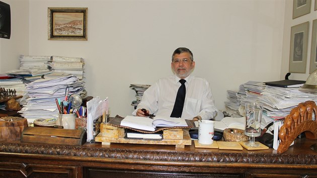 Skleněnou cenu Právník roku 2014 v oblasti trestního práva má ústecký advokát Jiří Císař na pracovním stole mezi hromadami spisů.