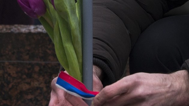 Mu v centru Moskvy uvazuje ruskou trikolrou kvtiny na pamtku zabitho Borise Nmcova (1. bezna 2015).