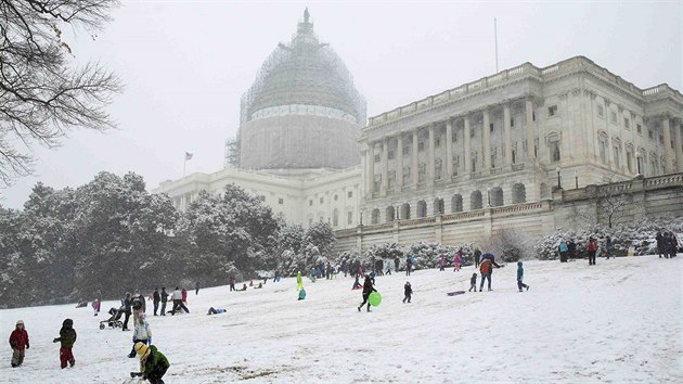 Jih a vchod Spojench stt zashla snhov boue. Na snmku je zpadn st budovy washingtonskho Kapitolu, ped nm skuj dti (5. bezna 2015).