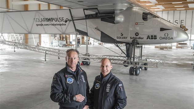 André Borschberg a Bertrand Piccard před letounem Solar Impulse 2 v hangáru na letišti Payerne