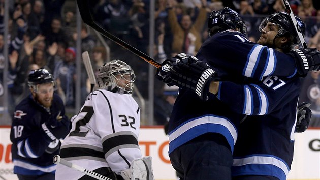 Michael Frolk (vpravo) z Winnipegu se raduje se spoluhrem Andrewem Laddem z glu v duelu s Los Angeles. Brank  Jonathan Quick je jen smutn sleduje.