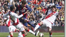 MEZI TEMI. Gerard Pique z Barcelony skóruje tísnný hrái týmu Rayo Vallecano.