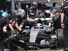 Lewis Hamilton a jeho vz pod hbitýma rukama mechanik.