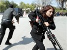 Policista a novináka utíkají ped parlamentem v Tunisku (18. bezna 2015).
