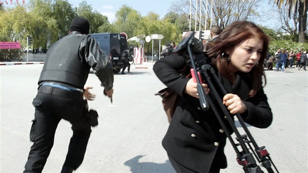 Policista a novinka utkaj ped parlamentem v Tunisku (18. bezna 2015).