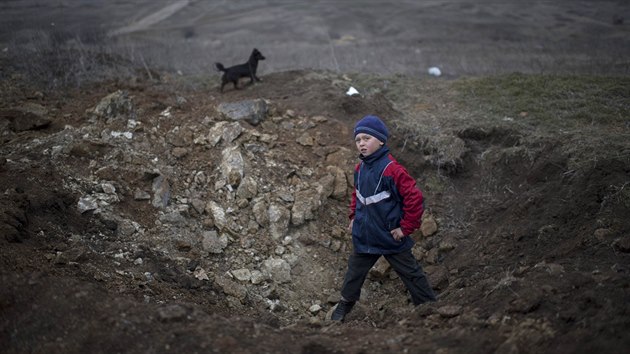Chlapec z vchodoukrajinskho ermalyku prolz krter, kter zstal po bojch armdy se separatisty. (26. nora 2015)