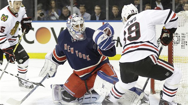 Jonathan Toews z Chicaga v anci ped brankem New York Rangers Camem Talbotem.