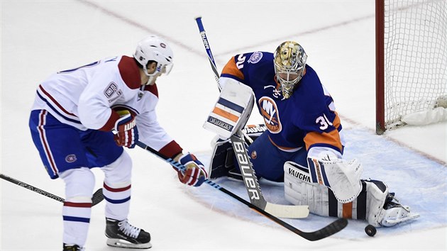 Michal Neuvirth (30) hj branku New Yorku Islanders proti Maxu Paciorettymu z Montrealu.