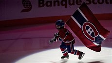 Malý brusla vyjel na led s vlajkou Montrealu Canadiens.