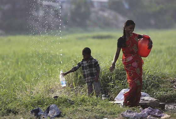Žena v Indii jde společně s chlapcem pro vodu (22. března 2015).