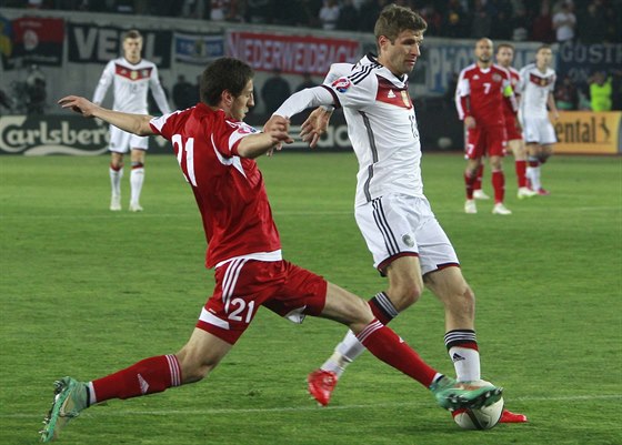 Nmecký fotbalista Thomas Müller (v bílém) v souboji s Laou Dvalim z Gruzie.