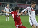 Nmecký fotbalista Thomas Müller (v bílém) v souboji s Laou Dvalim z Gruzie.
