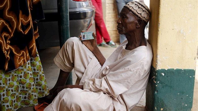 Muž v nigerském městě Daura čeká, až se dostane na řadu a volební komisaři ověří jeho totožnost. (28. března 2015)