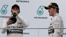 Lewis Hamilton si dává douek ampaského, týmový kolega Nico Rosberg ho se...