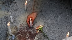 Lidé zapalují svíky v Tunisu na míst teroristického útoku (19. bezna 2015).