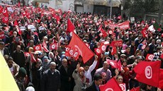 Tunisané mávají vlajkami bhem pochodu proti terorismu. (29. bezna 2015)