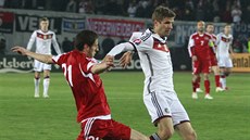 Německý fotbalista Thomas Müller (v bílém) v souboji s Lašou Dvalim z Gruzie.