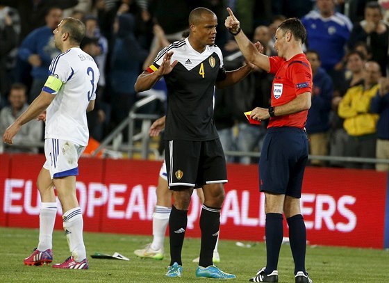 Belgický stoper Vincent Kompany diskutuje s rozhodím Markem Clattenburgem,...