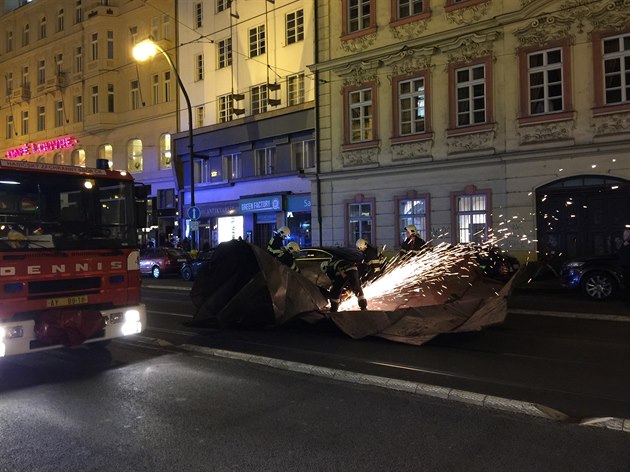 Hasii rozezávají plechovou stechu, která spadla na Národní tídu.