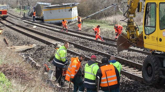 Železničáři museli na trati v Žalhosticích odklidit zbytky vozů, vyměnit pražce v délce asi 200 metrů a opravit poničené trakční vedení. (30. března 2015)