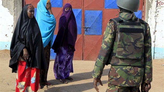 Keňský voják brání ženám se přiblížit k univerzitnímu areálu, kde zaútočil aš-Šabáb (2. dubna 2015).