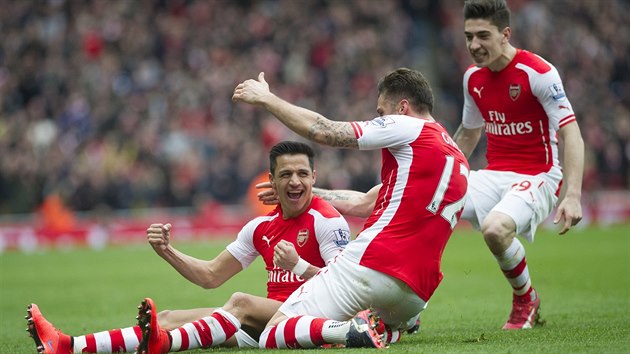 Fotbalist Arsenalu oslavuj branku Alexise Sncheze (vlevo).