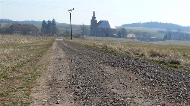 Povrch z minerálního betonu na cyklostezce od polské hranice do Vižňova se rozpadl, nahradí ho asfalt. V pozadí kostel. svaté Anny ve Vižňově.