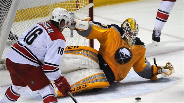 Elias Lindholm (16) z Caroliny poloil na led branke Anderse Lindbcka z Buffala.